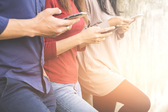 Three Young People Standing With Smart Phone In Hand, Having Fun Together Using  Technology Social Media On Internet