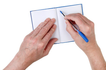An elderly man writes addresses of friends in a paper notebook