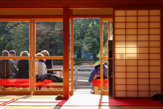 東京の庭園にある日本家屋でお茶を飲む観光客
