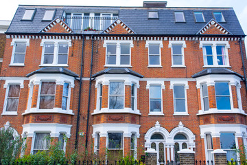 Facade of an opulent restored Victorian house in red bricks and white finishing in Clapham, South London, UK