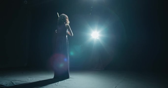 A Talented Girl Violinist Performs At Her First Solo Concert, Stage Light, Dark Background