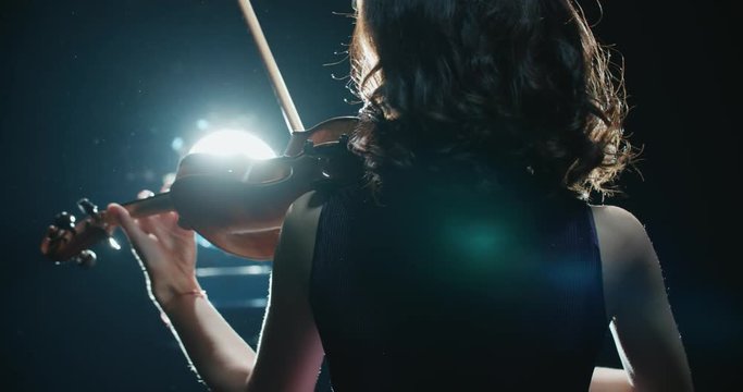 beautiful young girl playing the violin during the concert