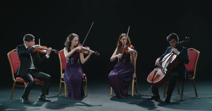 classical string quartet during the performance of the symphony, abstract black background