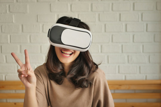 woman with vr headset giving v victory, 2 fingers gesture
