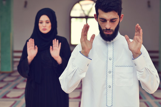 Muslim Man And Woman Praying In Mosque