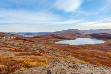 Autumn greenlandic wastelands landscape with lakes and mountains in the background, Kangerlussuaq, Greenland