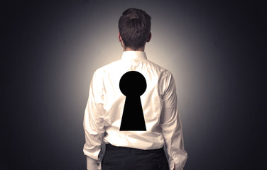 Man standing with black keyhole on his back