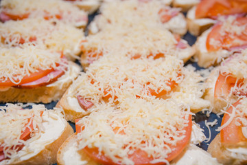 Tomato and cheese sandwich. The bread slice with tomato and cheese lies on a leaf.