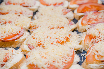 Tomato and cheese sandwich. The bread slice with tomato and cheese lies on a leaf.