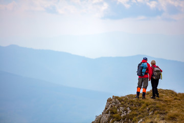 adventure, travel, tourism, hike and people concept - smiling couple walking with backpacks outdoors