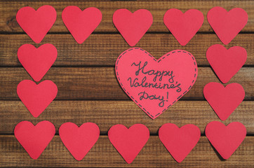 Cut out of red paper hearts on wooden background, congratulation with Valentine's day, top view