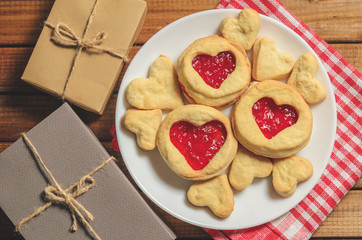 Homemade cookies in heart-shaped gifts and red paper hearts, greetings on Valentine's day, top view