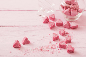 Granulated pink sugar  in the shape of heart on a wooden background