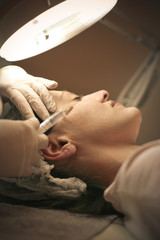Botox treatment. Young woman at beauty salon.
