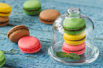 Green, pink, brown and yellow french macarons with mint leaves