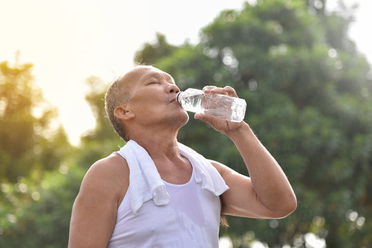 Asian senior male drinking water.