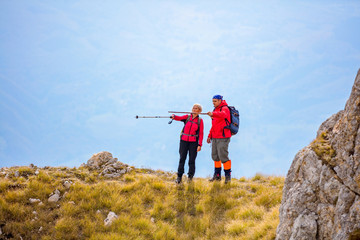 Obraz premium adventure, travel, tourism, hike and people concept - smiling couple walking with backpacks outdoors