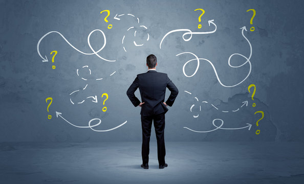 Unsure businessman with question marks