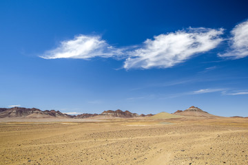 Fototapeta na wymiar Beautiful wide angle view of the Namibian Desert and mountains in the background at the road between Vioolsdrift and Aussenkehr near the South African border. Blue sky and beautiful clouds.