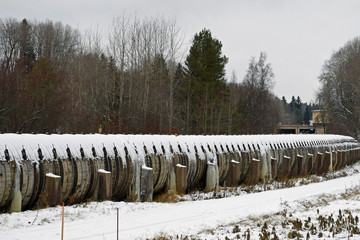 Fototapeta premium Old long wooden water pipe with many leaks in winter. Ice formed from trough pipe leaks.