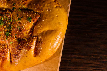 Pita bread with garlic on a wooden cutting board. Top view