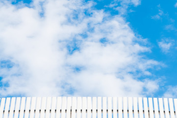 Wooden fence with cloud and blue sky.