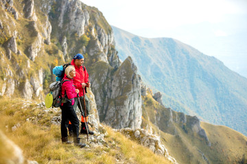 adventure, travel, tourism, hike and people concept - smiling couple walking with backpacks outdoors