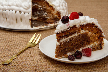 Sliced homemade biscuit cake decorated with whipped cream