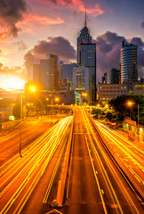 Fototapeta na wymiar Traffic at central district in Hong Kong at sunrise time. Car light trails and urban cityscape in Hongkong city .