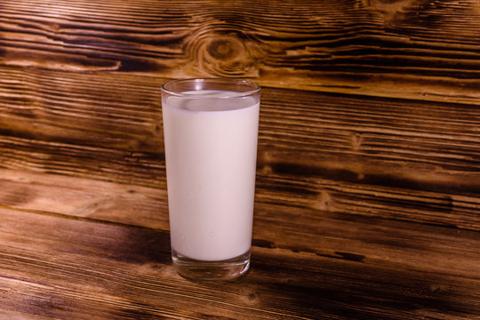 Full glass of milk on a wooden table