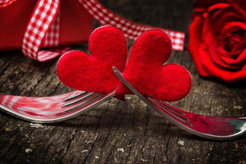 Valentinstag, Herzen auf Gabeln vor Rose und Geschenk