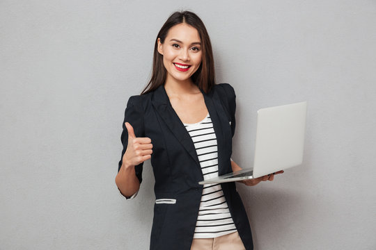 Holding business woman holding laptop computer and showing thumb up