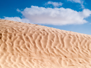 Tunisian desert landscape, Douz south of Tunisia, dune and blue sky with clouds