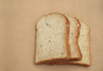 Whole grain bread on natural brown texture background with space for text.