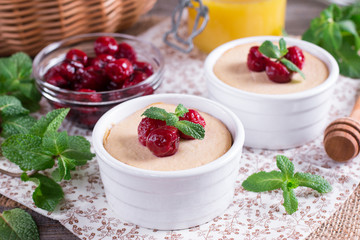 Dessert with cherries in white ceramic form