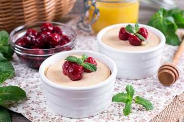 Yoghurt with fresh juicy cherries on a wooden table