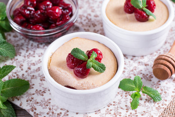 Dessert with cherry in a glass jars on wooden background