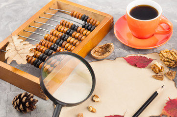 Old abacus and full cup of coffee and burnt blank paper and nut and red leaves with leaf of oak and...