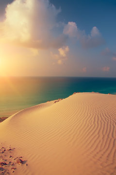 beautiful view of the sunset at the sea with a sand dune. Sea calm sunset view.
