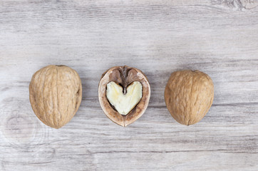 Three walnuts, the one in the middle has a hearted shape interior. Healthy eating concetp. Walnuts are good fot your heart.
