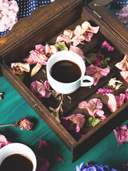 Cups of espresso coffee and flowers on dark green winter fall background