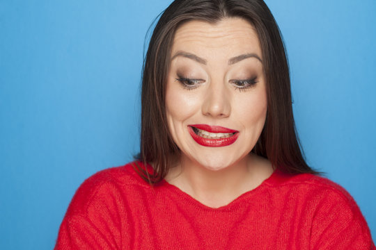 picture of woman  in a red blouse on a blue background with facial expression of mistake