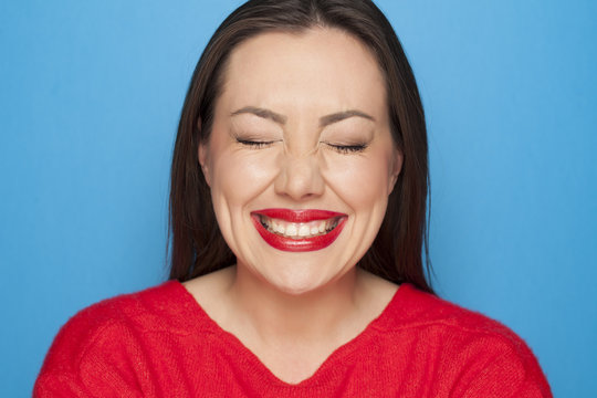 beautiful ashamed woman in a red blouse on a blue background
