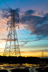 The silhouette of the evening electricity transmission pylon