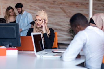 Beautiful phone operator Arab woman working in modern startup office