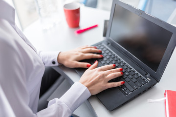 business woman working on laptop computer in the office closeup. No face