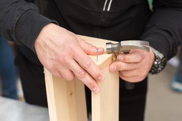 outdoor, handmade, repair equipment concept. close up of silver nail that isnt drived yet in wooden rough boards that bond for crafting nesting house for birds that cant live without it