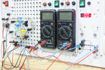 technology, electicity, factory concept. there are two multimeters that connected with dashboard...