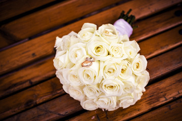 Wedding bouquet of white roses on a bench.
