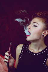 Mujer joven fumando en cachimba
